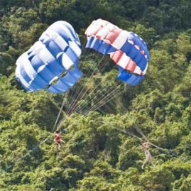 parasails against a jungle backdrop on the phuket coast