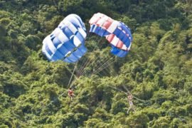 parasails against a jungle backdrop on the phuket coast